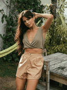Modelo usando blusa cropped Sara verde da marca Greenish, com decote em V e caimento soltinho, no ambiente ao ar livre.