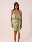 Mulher vestindo BLUSA THÁ - VERDE da Greenish com alças finas e tecido texturizado. Visual romântico e leve com pala dupla.