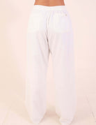 Calça Reta Milena - Off White vista traseira, destacando caimento reto e cós estruturado em tecido suave.