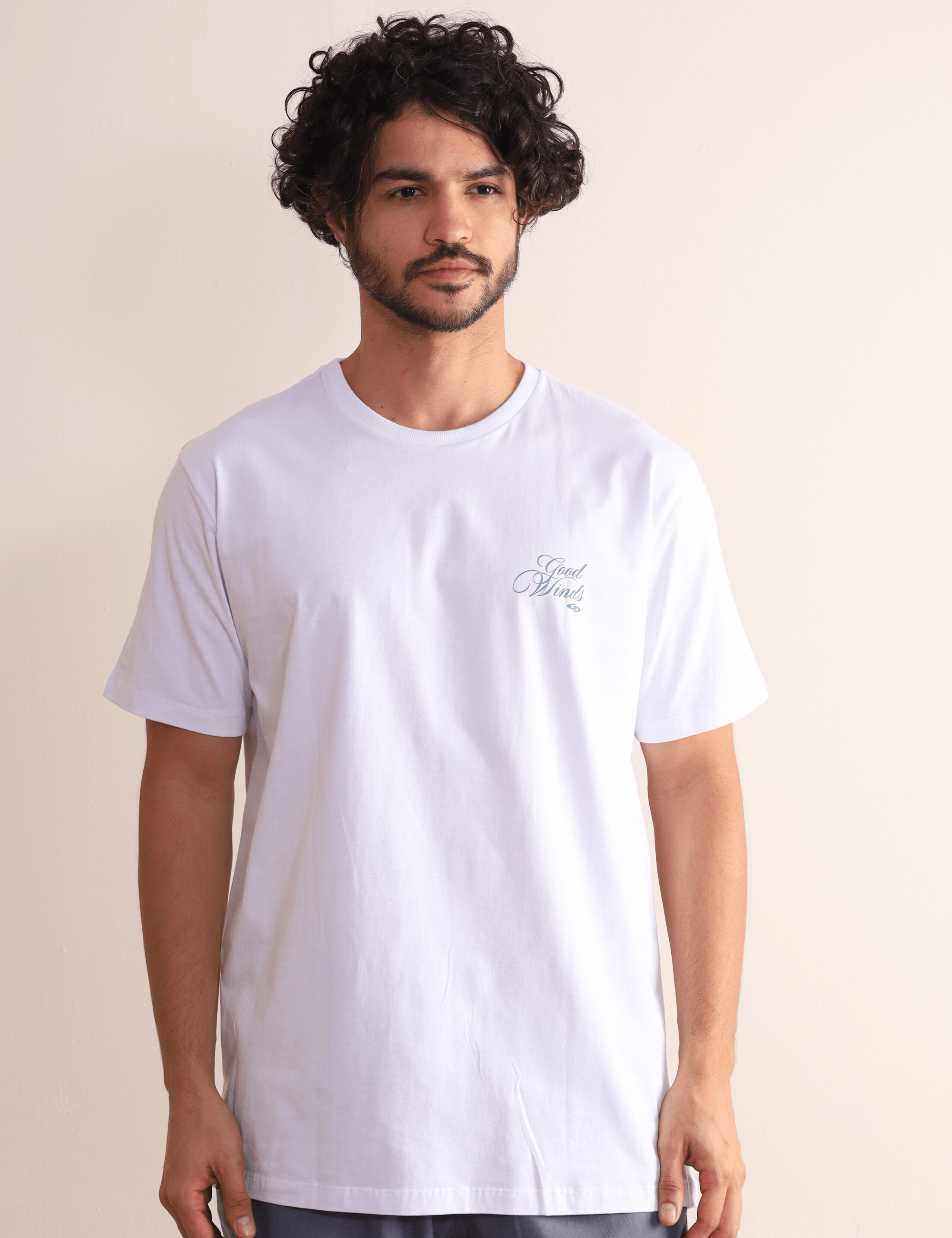 Homem vestindo camiseta branca Kites & Good Winds da marca Greenish, com bordado frontal, modelagem clássica e toque macio em algodão.