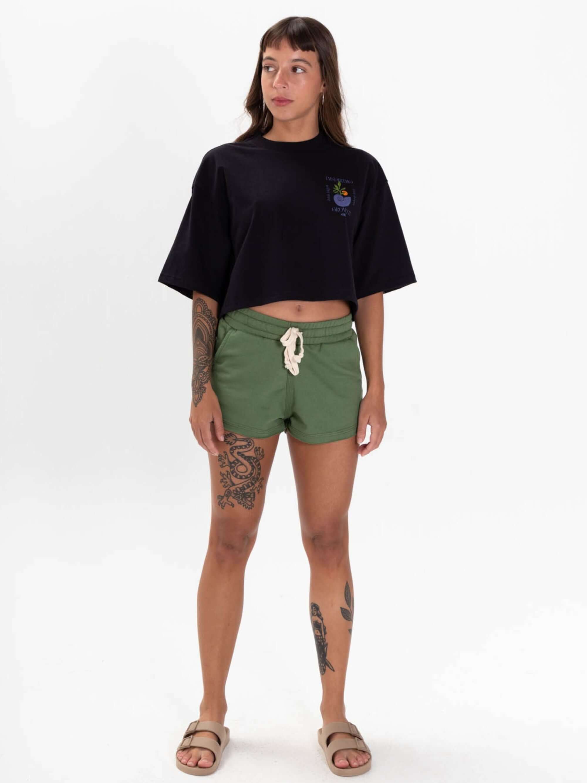 Camiseta cropped preta da Greenish, estilo casual, combinando com shorts verdes, look moderno e confortável.