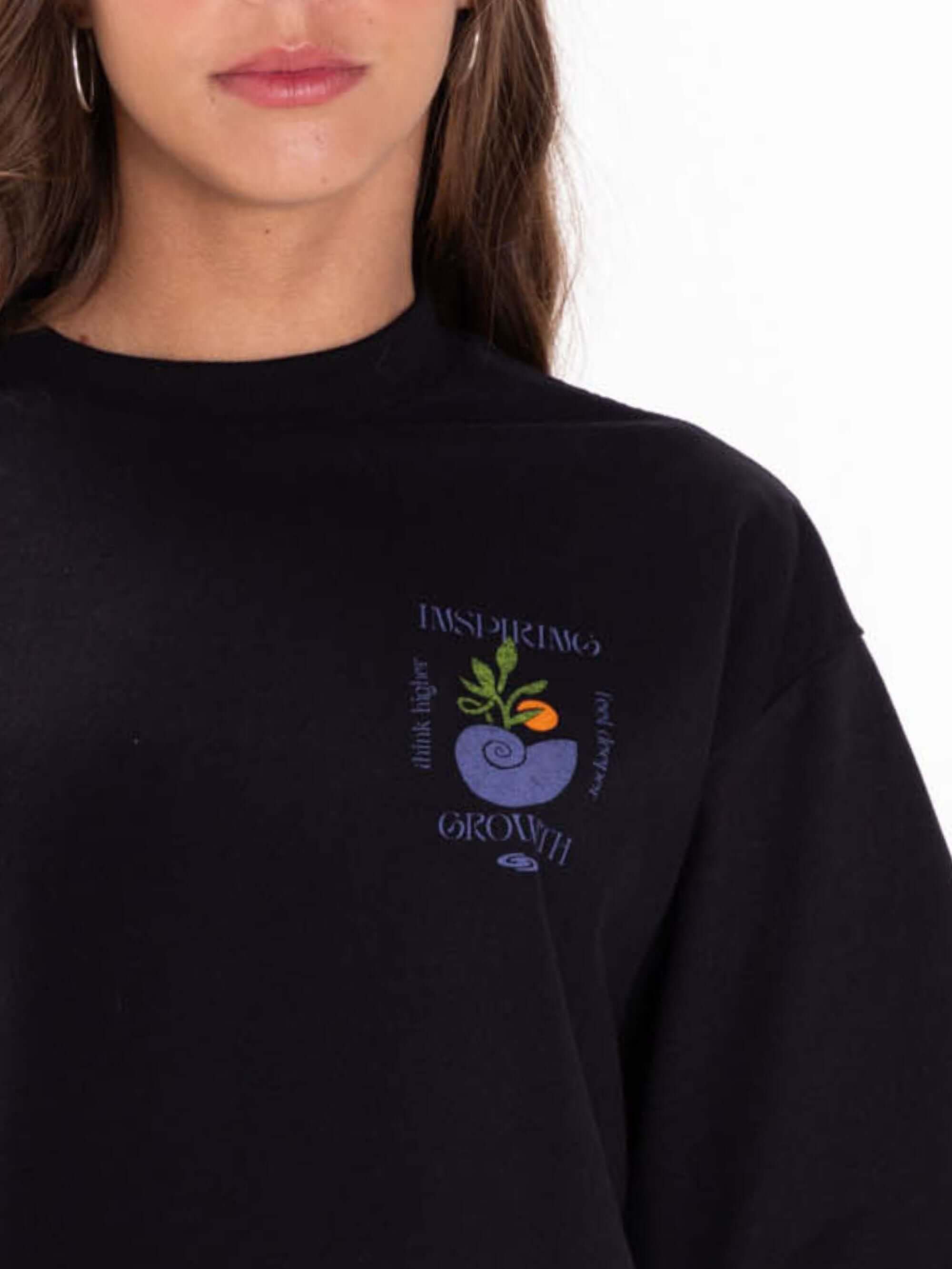 Camiseta cropped preta da marca Greenish com estampa "Inspiring Growth" em destaque.