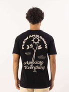 Camiseta preta da Greenish com estampa 'Flow and Grow' e 'Apreciate Everything' nas costas.
