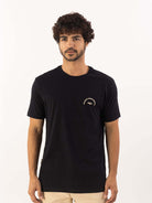 Homem usando a camiseta Everything preta da marca Greenish, com estampa clássica e confortável em 100% algodão.