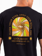 Camiseta preta Greenish com estampa de sol e slogan "Close Your Eyes, Open Your Soul" ao fundo.