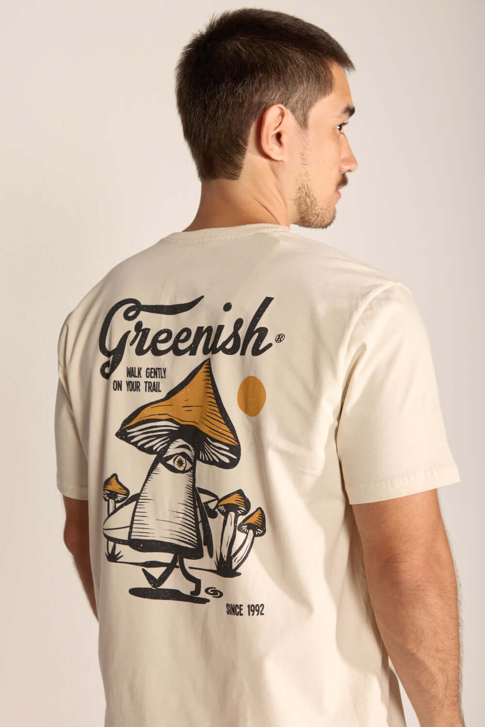 Camiseta Gentle Mushroom Bege com estampa de cogumelos e logo Greenish, simbolizando natureza e autoconhecimento.