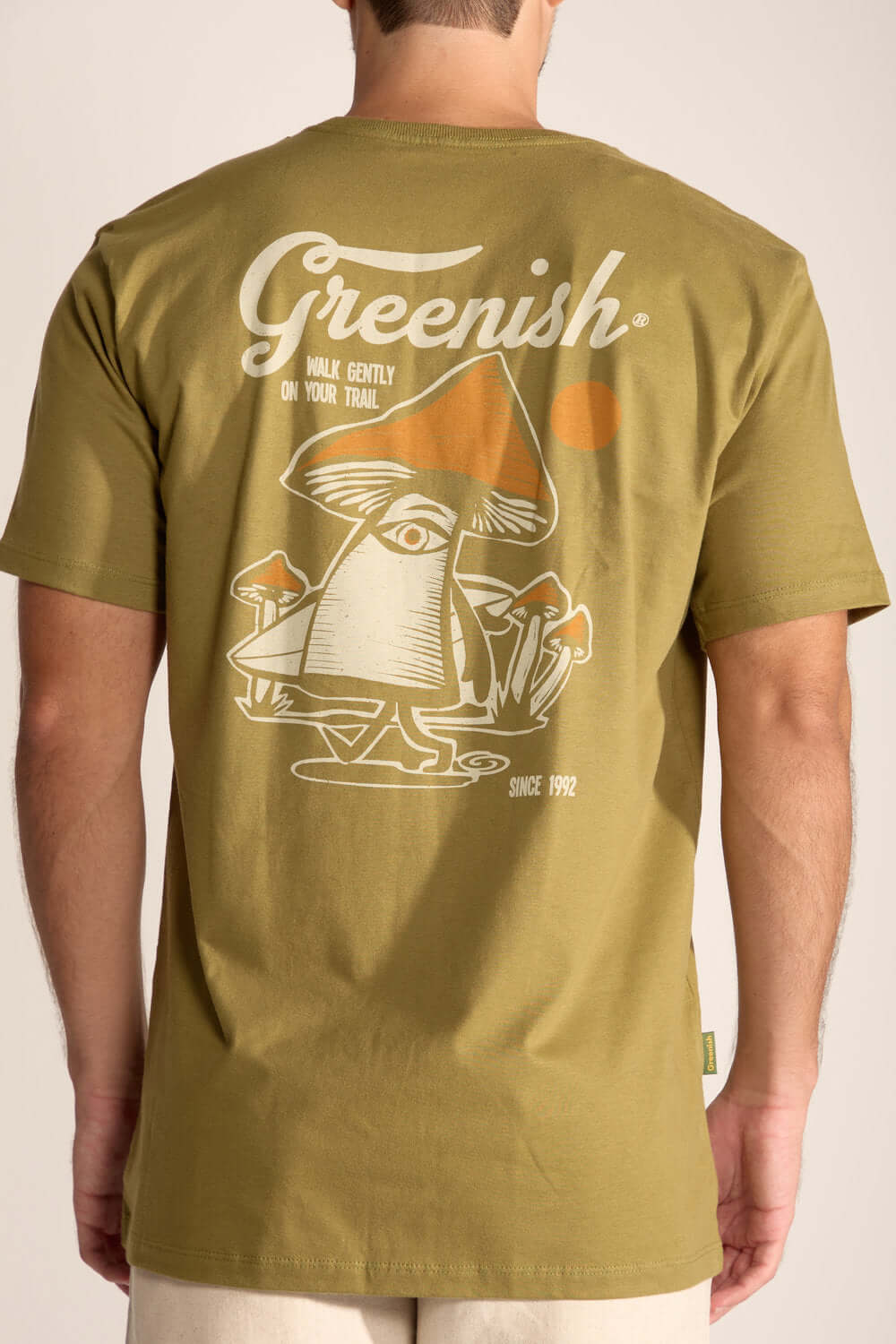 Camiseta Gentle Mushroom Verde Oliva com estampa divertida de cogumelo nas costas, simbolizando conexão com a natureza.
