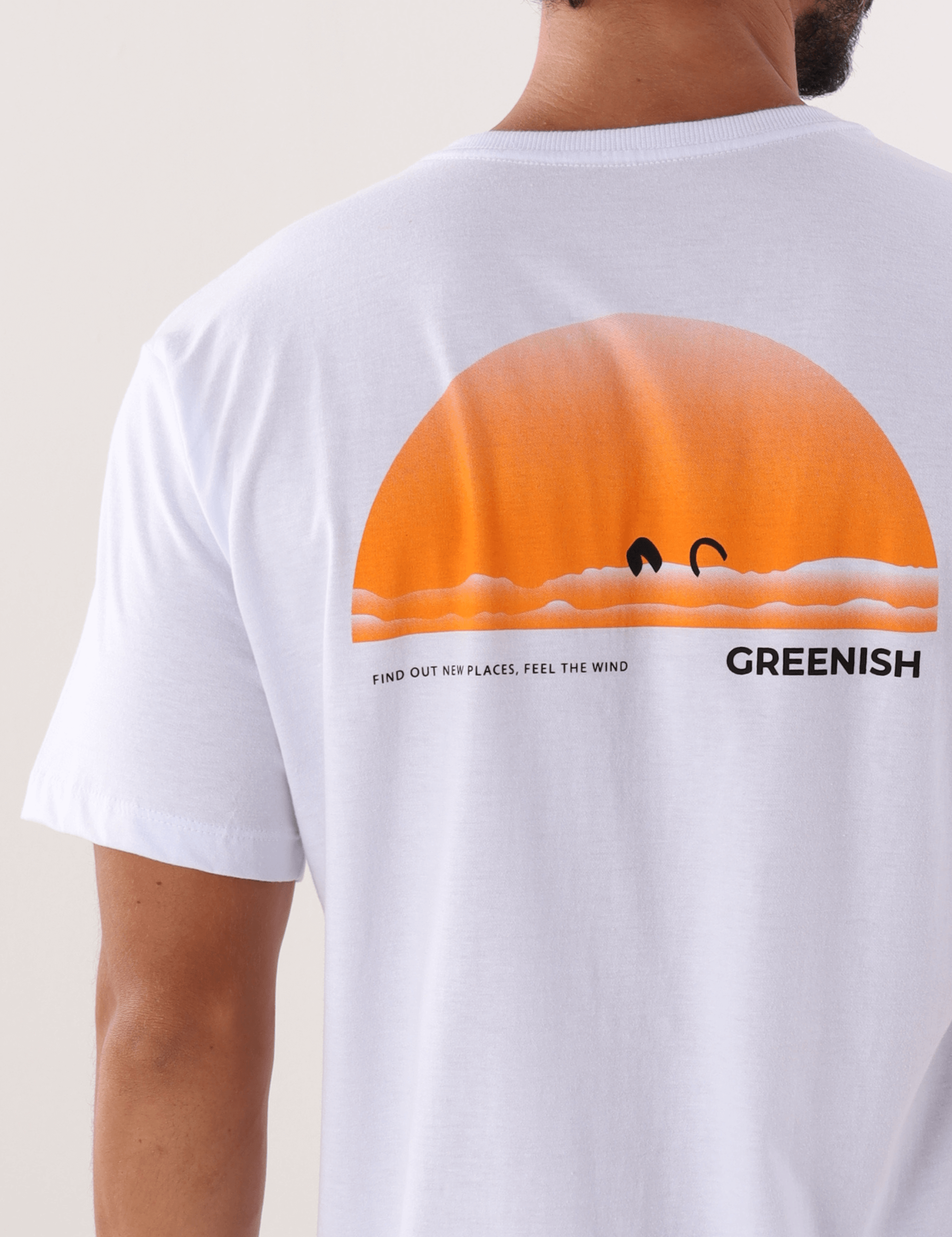 Camiseta branca 'Find Out New Places' da marca Greenish, apresentando design de pôr do sol laranja na parte traseira.