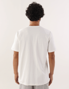 Homem vestindo camiseta Greenish Off White vista de costas, na cor branca. Moda casual masculina com qualidade e estilo.