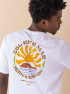 Camiseta branca Jeri Sol Kite Mar da marca Greenish, com estampa colorida de sol e mar nas costas.