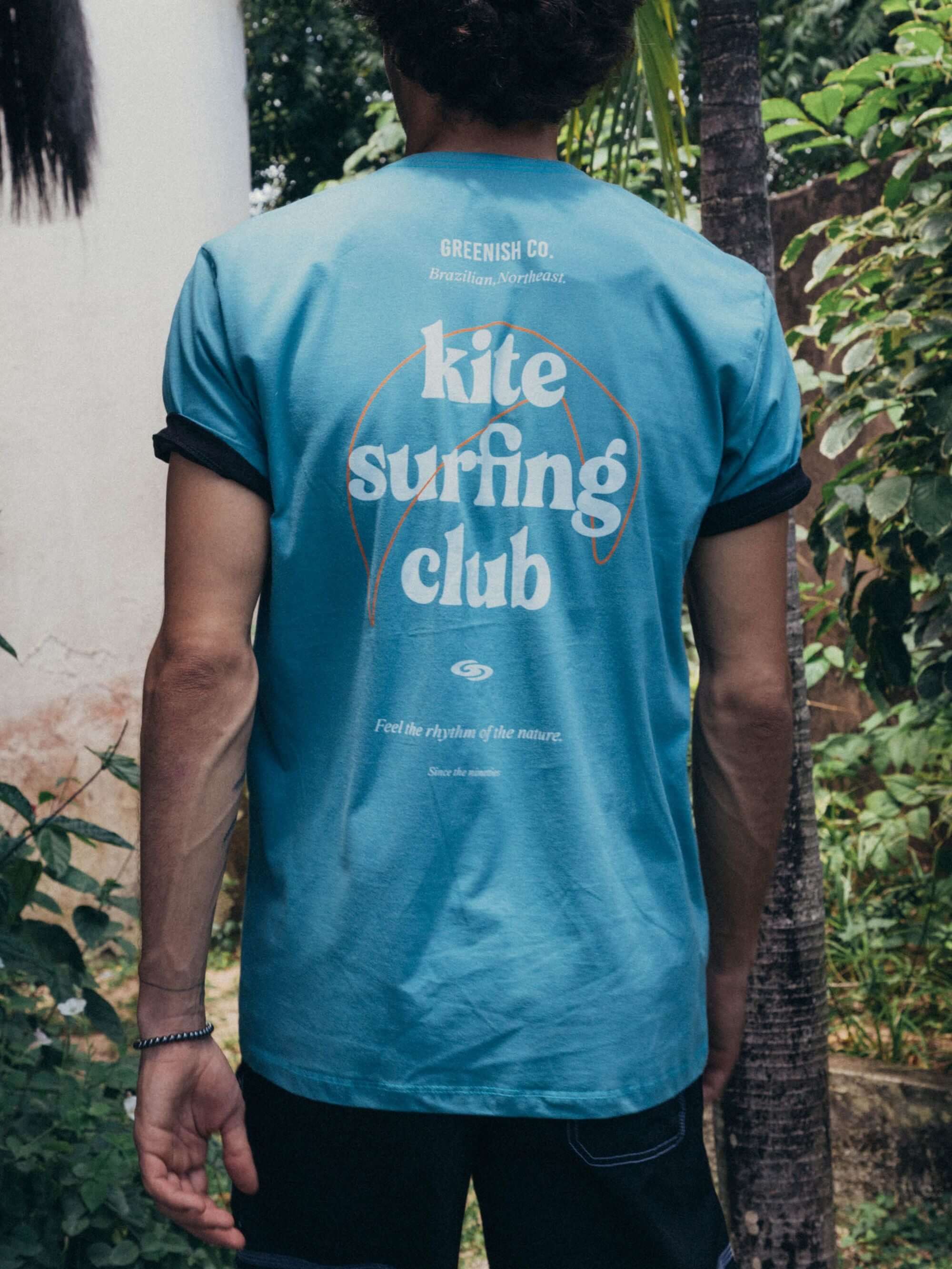 Camiseta azul médio Kite Surfing Club da Greenish, perfeita para amantes de esportes aquáticos e dias quentes.