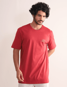 Homem vestindo Camiseta Kites & Good Winds Vermelho da Greenish, modelo clássico em algodão com bordado frontal, ideal para conforto e estilo.