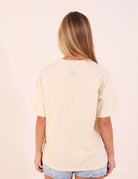 Parte traseira da Camiseta Oversized Breeze - Bege com detalhe moderno do recorte, confeccionada em Malha Essencial Touch.