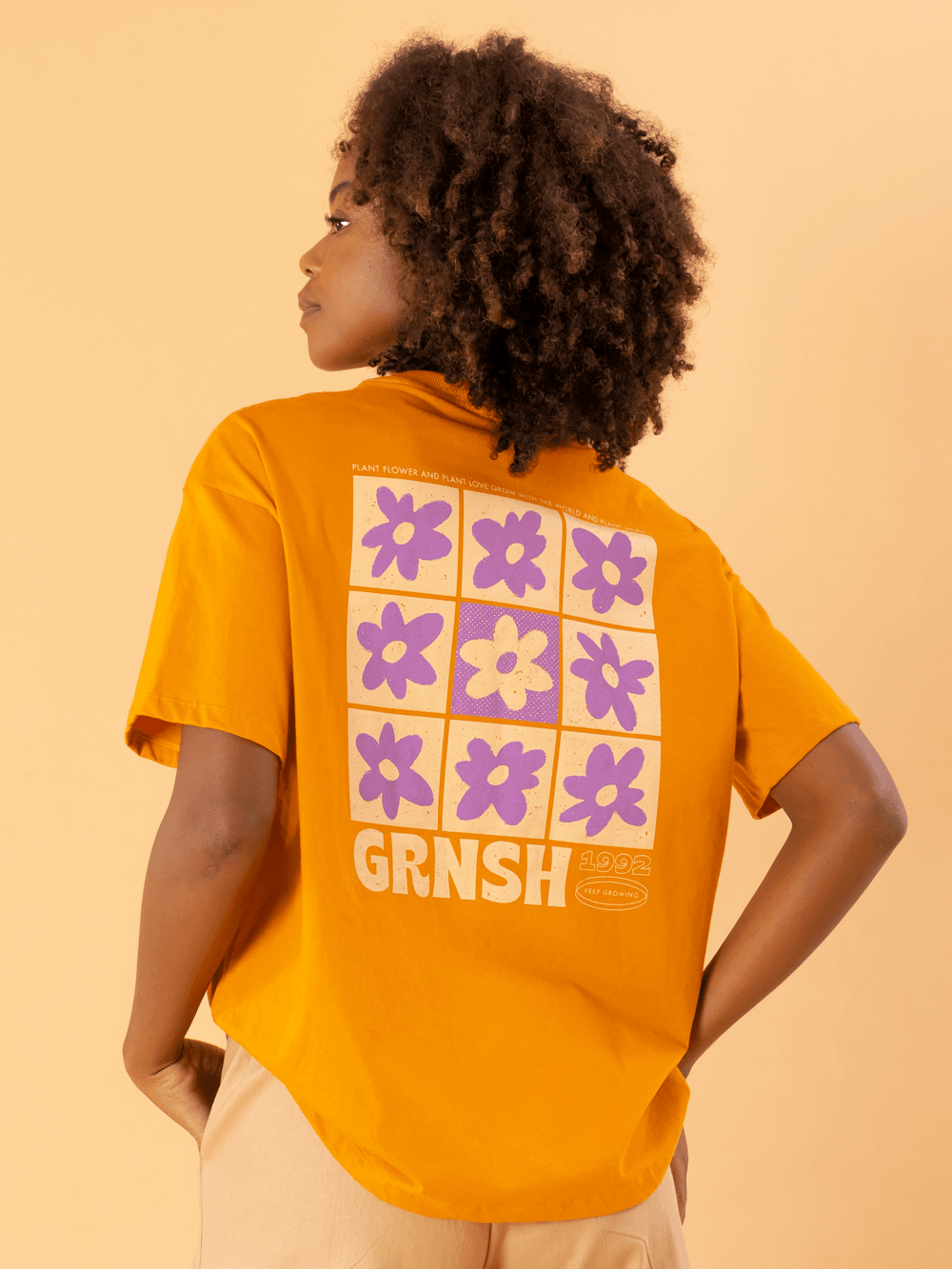 Camiseta oversized laranja com estampa floral da marca Greenish, modelo feminino e confortável.