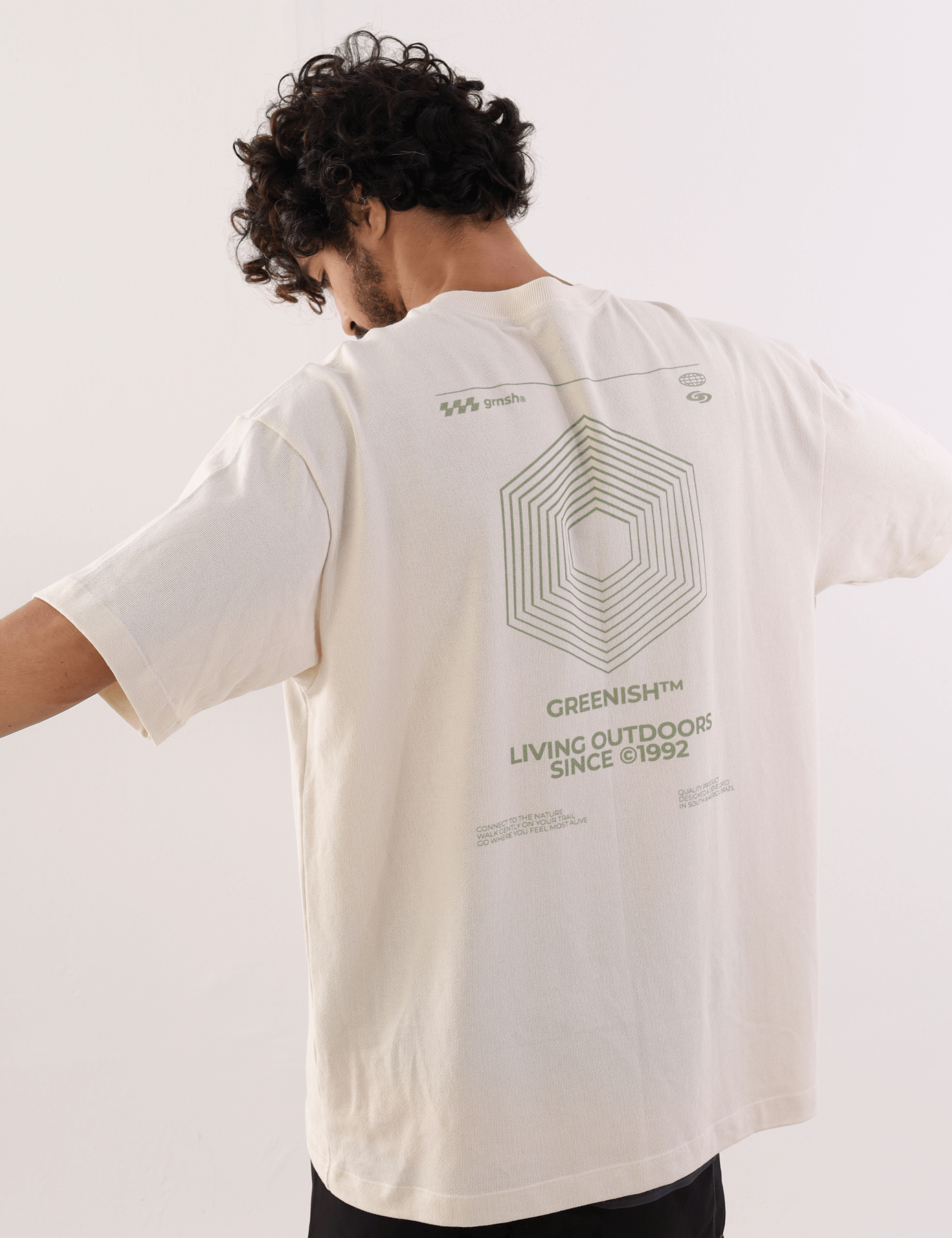 Homem vestindo Camiseta Oversized Hexagon Lines - Bege da marca Greenish, destacando design geométrico nas costas, ideal para estilo casual.