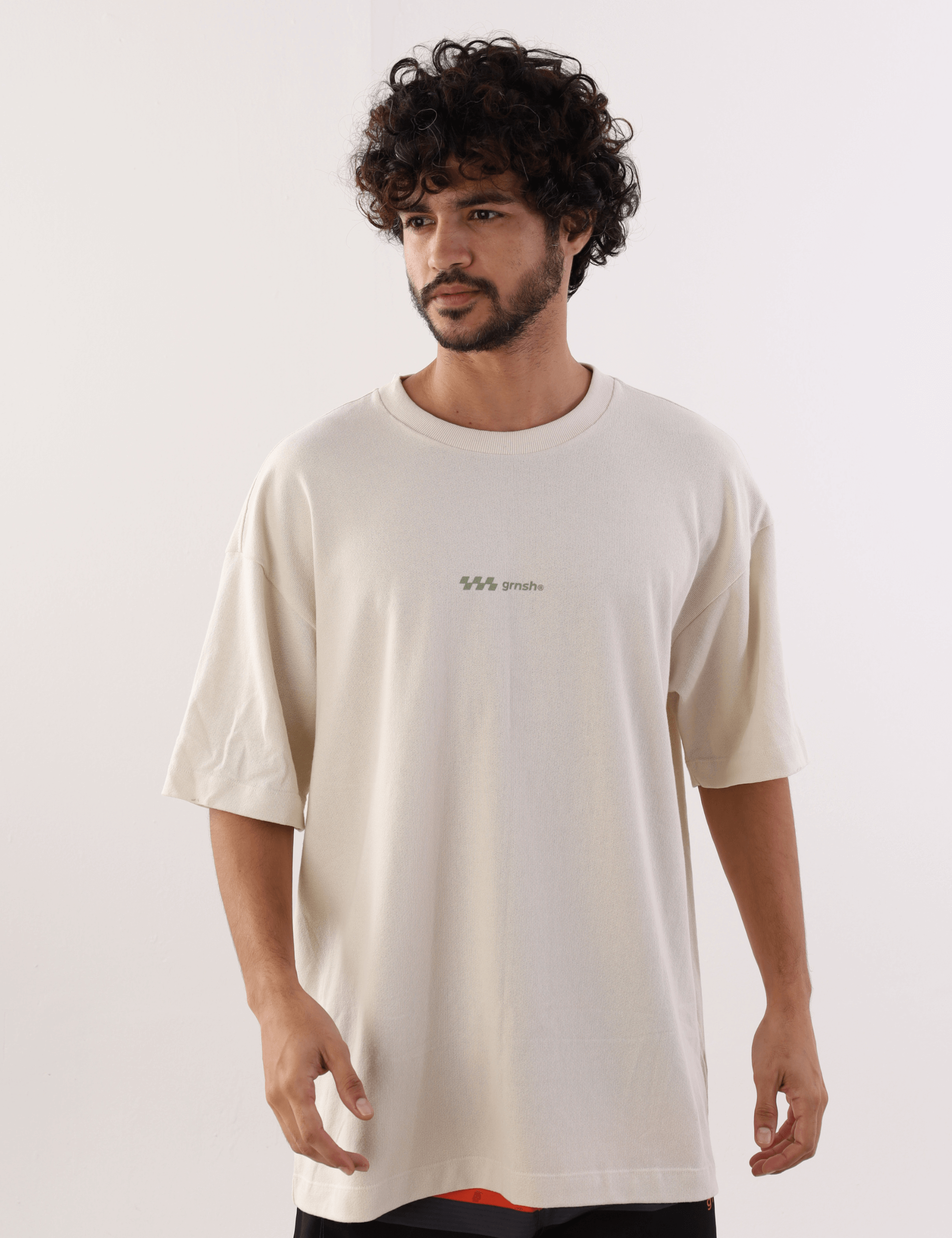 Homem vestindo Camiseta Oversized Hexagon Lines Bege da marca Greenish, com design de linhas hexagonais em algodão confortável.