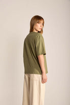 Camiseta Oversized Verde Walk Gently da Greenish, modelo feminino visto de costas com estilo descontraído.