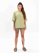 Camiseta oversized verde da Greenish com estampa de palmeiras em aquarela, estilo moderno e confortável.