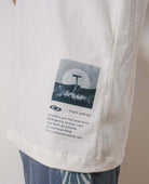 Camiseta oversized off white da Greenish com estampa de cogumelo e mensagem inspiradora na lateral.