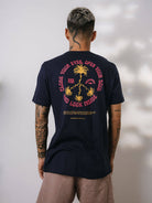 Modelo usando camiseta azul marinho da Greenish com estampa tropical nas costas, ideal para qualquer ocasião.