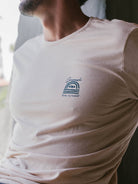 Camiseta Sunset Bege da marca Greenish, com estampa de arco-íris e detalhe em azul no peito.
