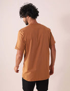 Homem vestindo CAMISETA TRADICIONAL BASIC - MARROM da Greenish, feita de algodão sustentável com selo BCI, vista traseira.