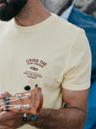 Camiseta Vintage Feel Alive amarela da Greenish, estampada com 'Living the Surf Dreams', ideal para amantes de surf.