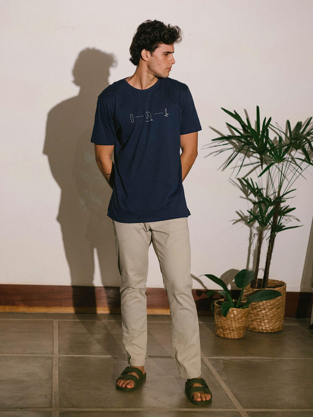 Camiseta Wind Free azul marinho da Greenish, modelo casual em ambiente moderno com plantas.