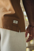 Camiseta Greenish Quality Product - Caqui com design minimalista, silk localizado e etiqueta termocolante. Ideal para o dia a dia.