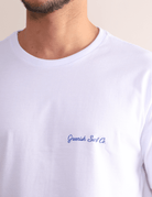 Camiseta branca Greenish Made By Surfers em algodão com estampa minimalista frontal. Perfeita para praia e momentos descontraídos.