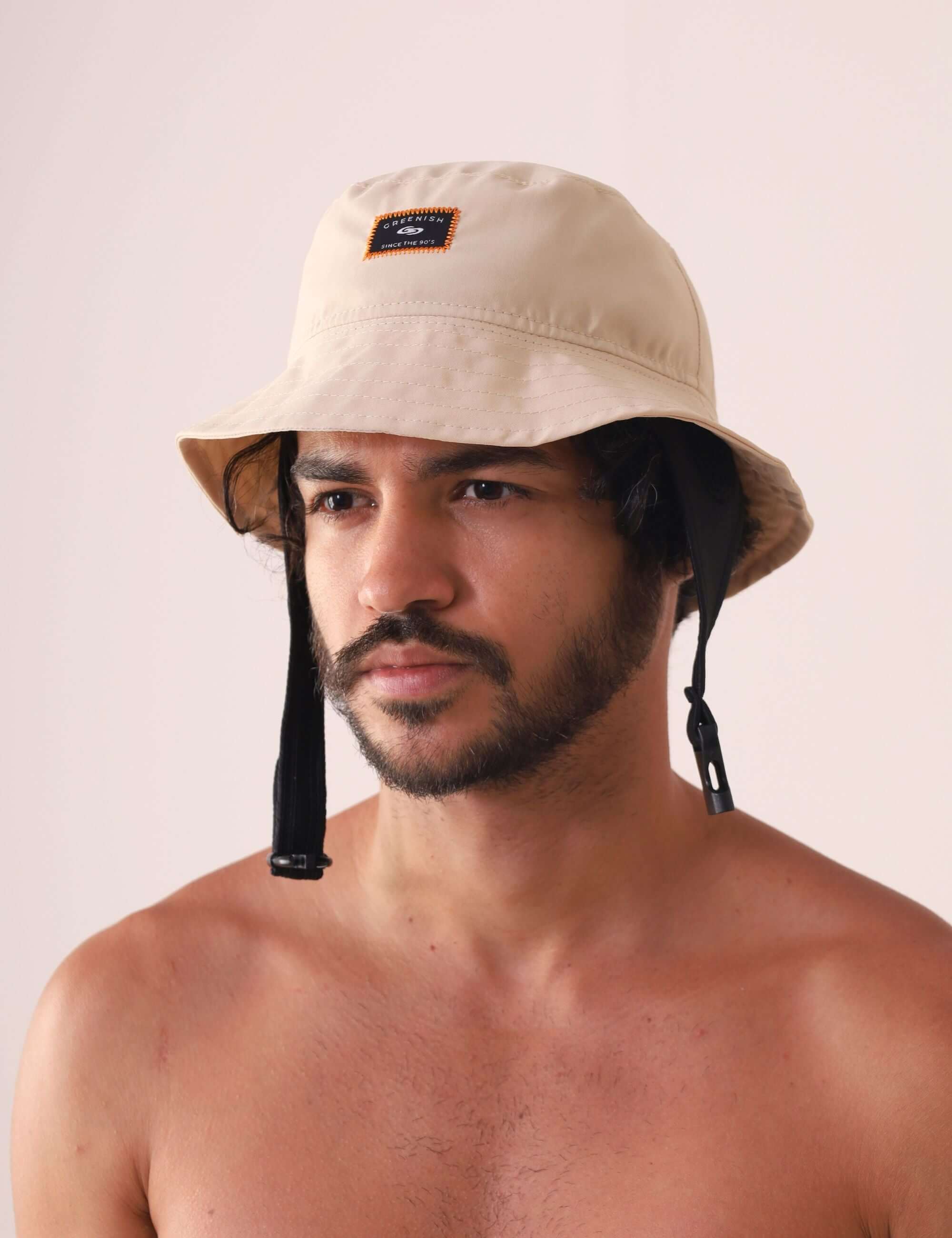 Modelo usando Chapeu Bucket Sport - Bege da Greenish em poliéster com aba e cordão ajustável para práticas ao ar livre.