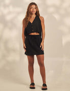 Blusa Sunset - Preto Greenish: colete cropped em algodão com botões frontais, decote e cava a fio, transpasse nas costas e fenda, visual despojado