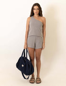 Model wearing Blusa Tricot Ombro Só Fer - Grafite by Greenish, holding a dark bag, showcasing stylish fashion.