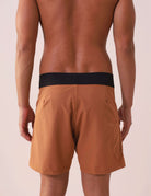 Homem vestindo BOARDSHORT CLASSIC TRUNK ESSENCIAL - CAQUI da Greenish, destacando modelagem anatômica e bolso funcional.