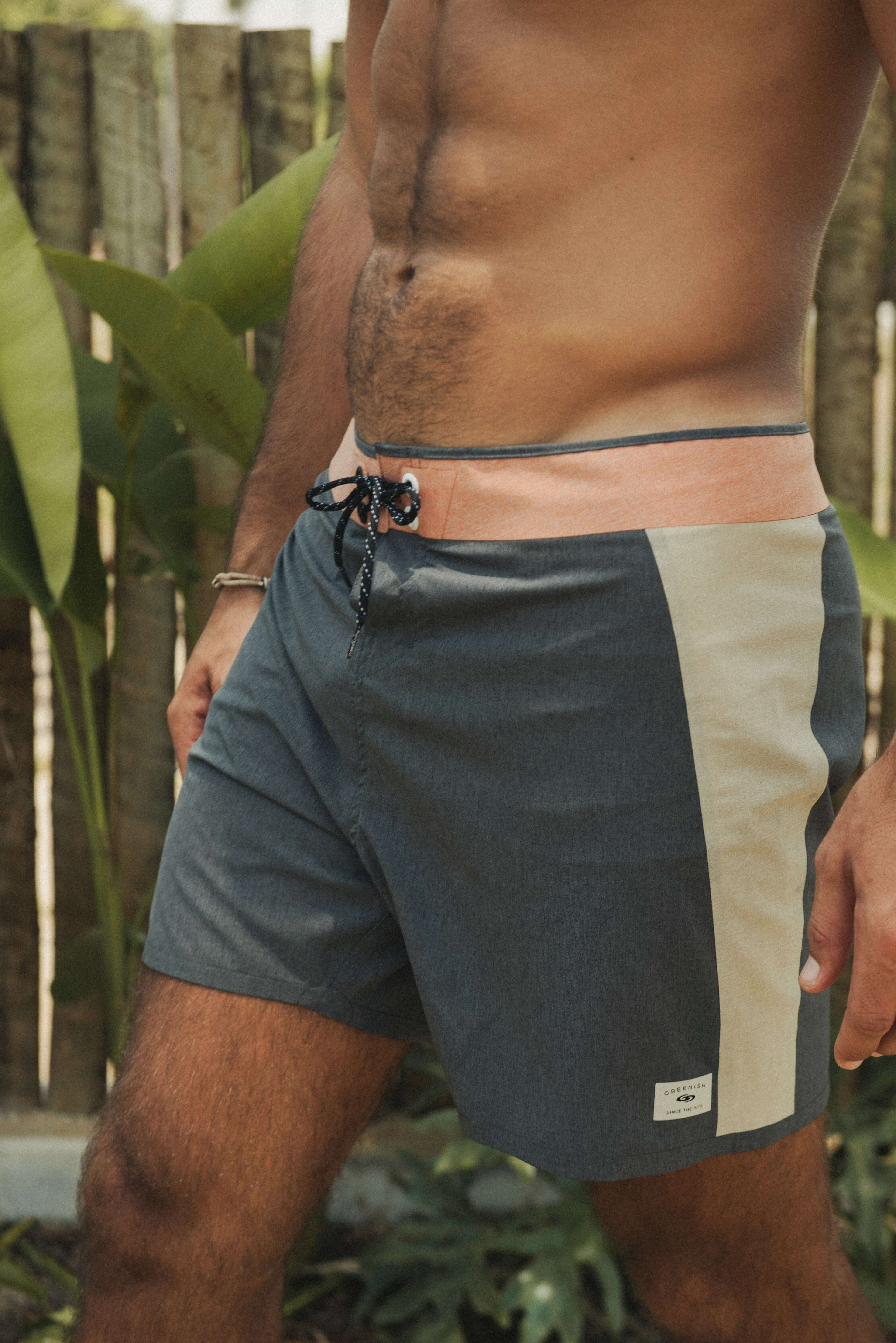 Homem usando BOARDSHORTS ULTRALIGHT II SUNSET - PRETO da Greenish com design multicolorido ao ar livre.