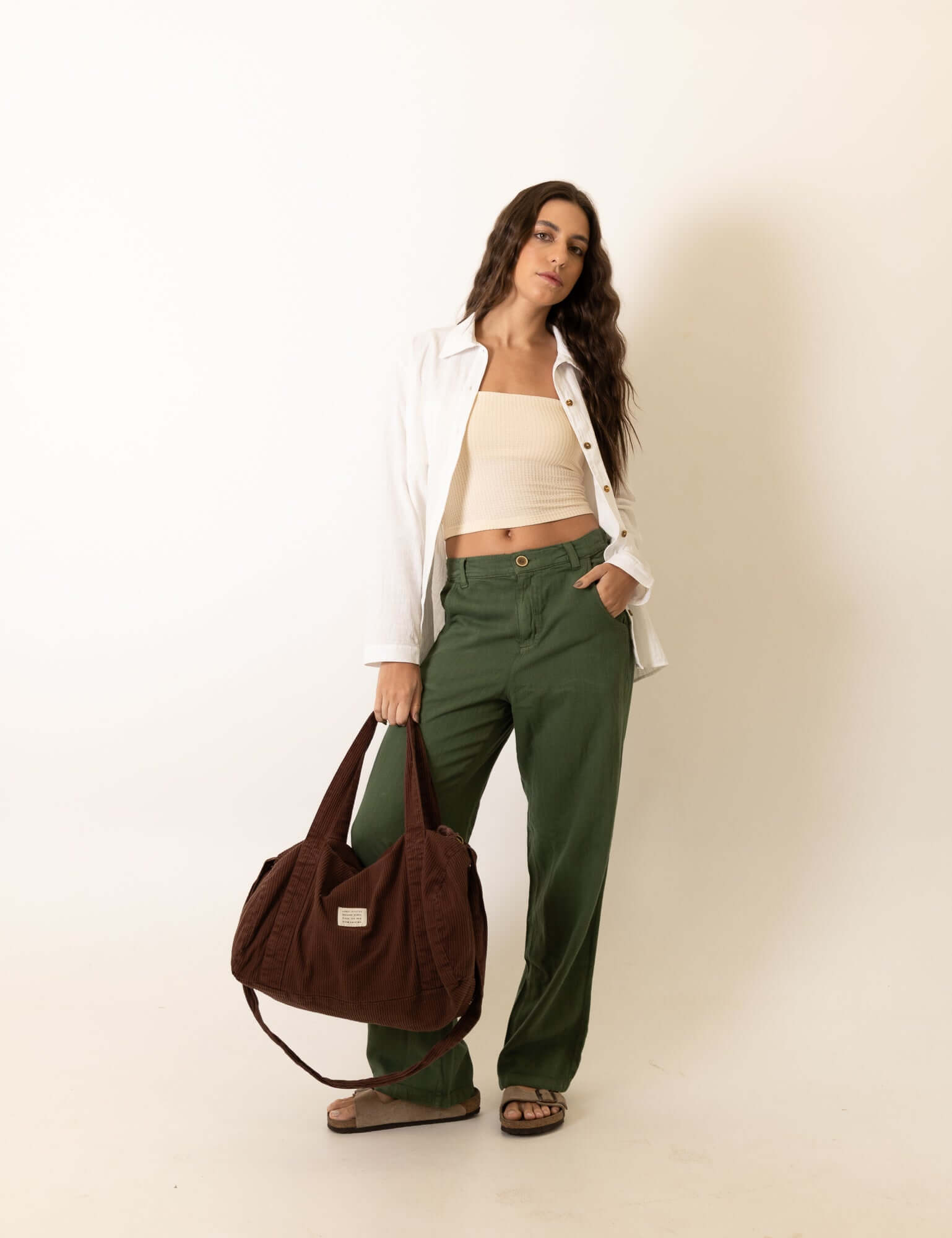 Mulher vestindo Calca New Khay - Verde Escuro da marca Greenish em ambiente casual, destacando conforto e estilo com toque fresco de linho.