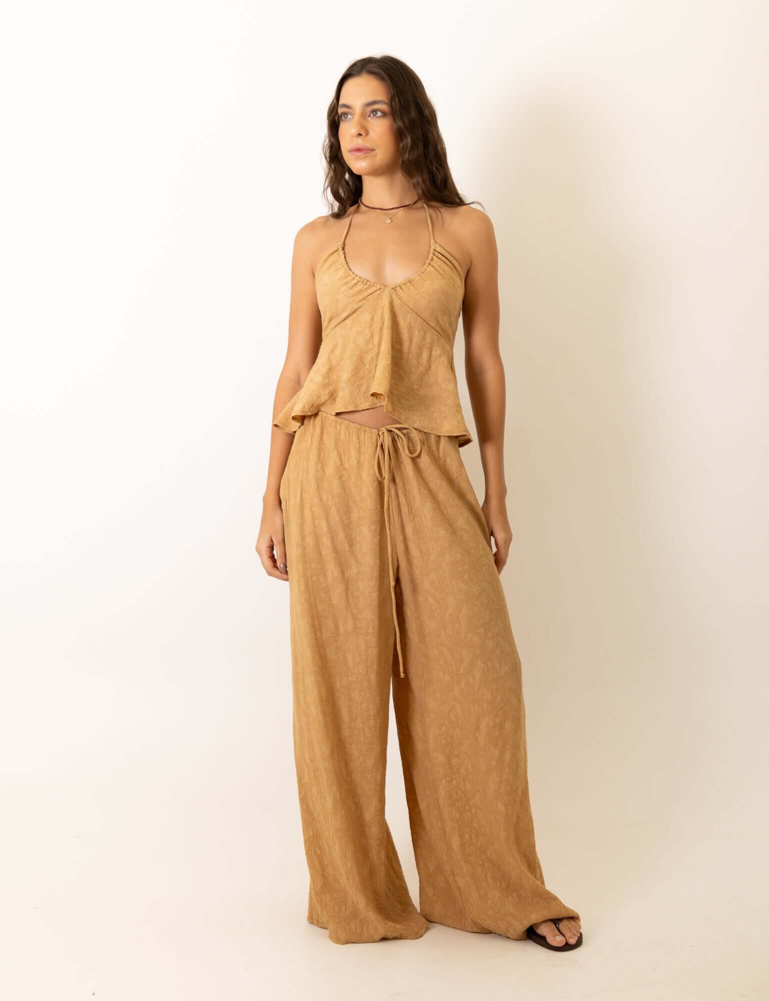 Mulher vestindo Calca Pantalona Regulavel Paisley - Caqui da marca Greenish, destacando conforto e estilo casual elegante. Ideal para todas as ocasiões.