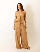 Mulher vestindo Calca Pantalona Regulavel Paisley - Caqui da marca Greenish, destacando conforto e estilo casual elegante. Ideal para todas as ocasiões.