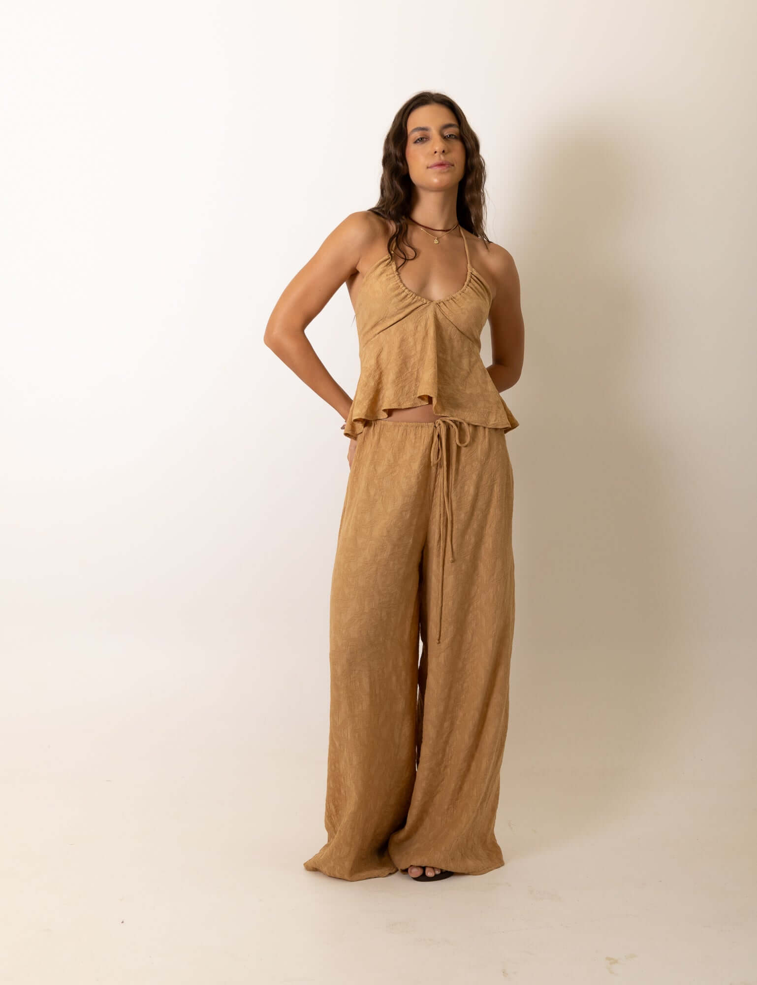 Modelo vestindo a Calca Pantalona Regulavel Paisley - Caqui da marca Greenish em estúdio.