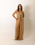 Modelo vestindo a Calca Pantalona Regulavel Paisley - Caqui da marca Greenish em estúdio.