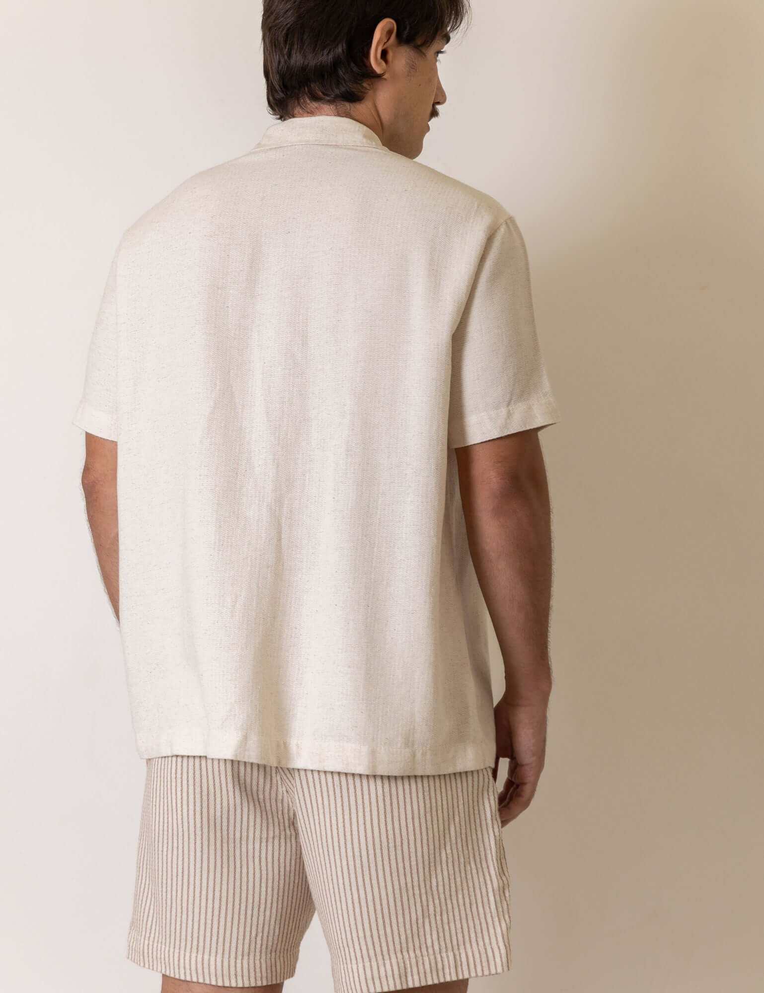 Modelo vestindo Camisa Botao Brisa - Natural da Greenish, vista traseira