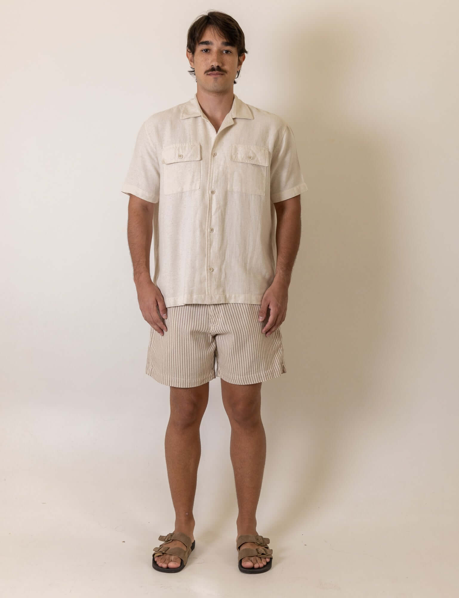 Greenish Camisa Botao Brisa - Natural worn by a model, showcasing the natural color and button detail in a casual setting.