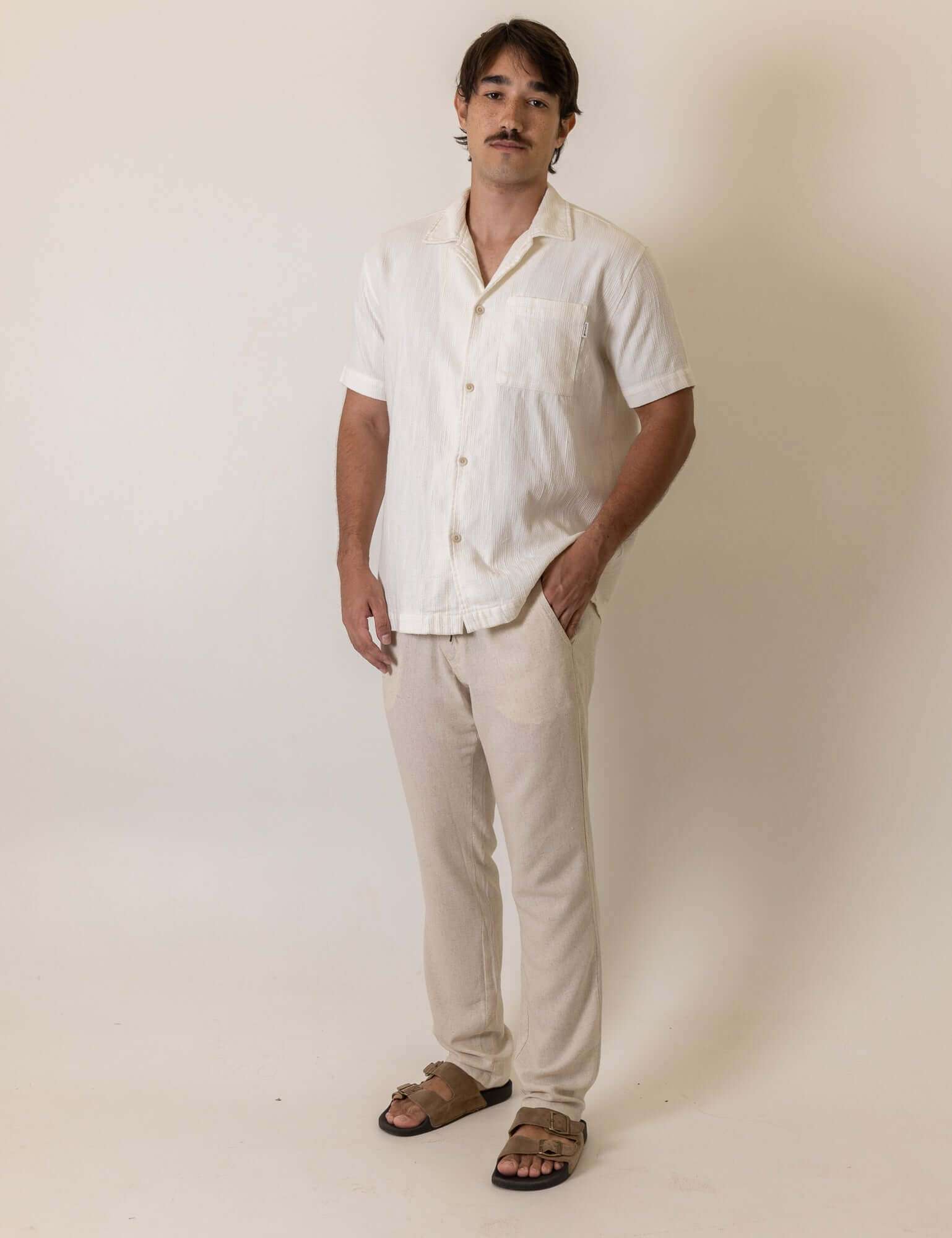 Homem vestindo Camisa Botao High Tide - Off White da marca Greenish, destacando um estilo casual e elegante em tom claro.