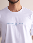 Camiseta branca Greenish 'Wind is All I Need' com estampa frontal, leve, estilosa e confortável, perfeita para movimento.