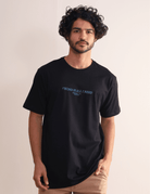 Camiseta preta Greenish 'Wind Is All I Need' com modelagem confortável e estampa frontal, perfeita para estilo e conforto.