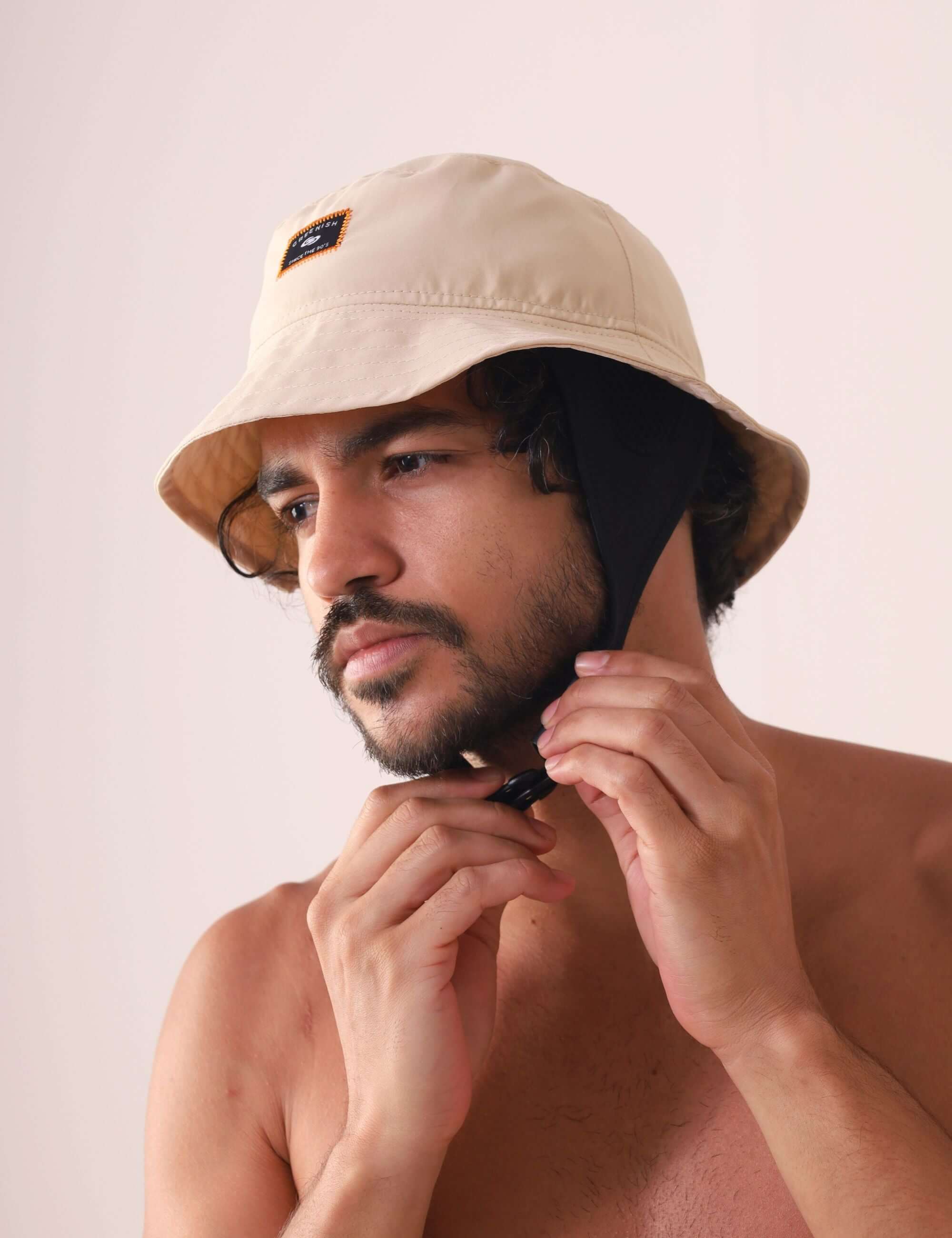 Homem usando Chapeu Bucket Sport - Bege da Greenish com cordão de neoprene ajustável para conforto ao ar livre.