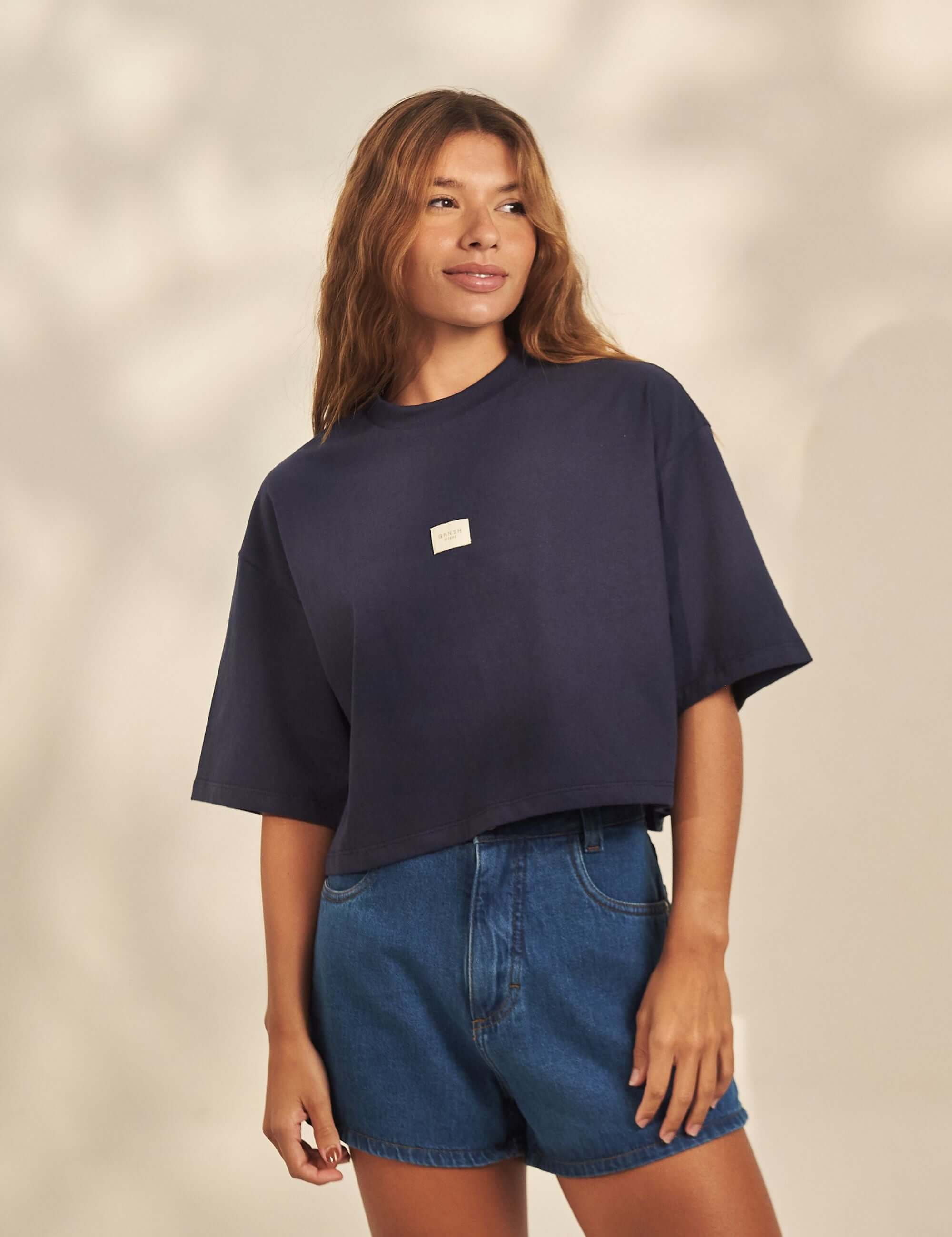 Alt Tag: Cropped Oversized Grnsh - Azul Marinho da Greenish em malha 100% algodão, modelagem ampla e comprimento cropped, detalhe etiqueta frontal GRNSH