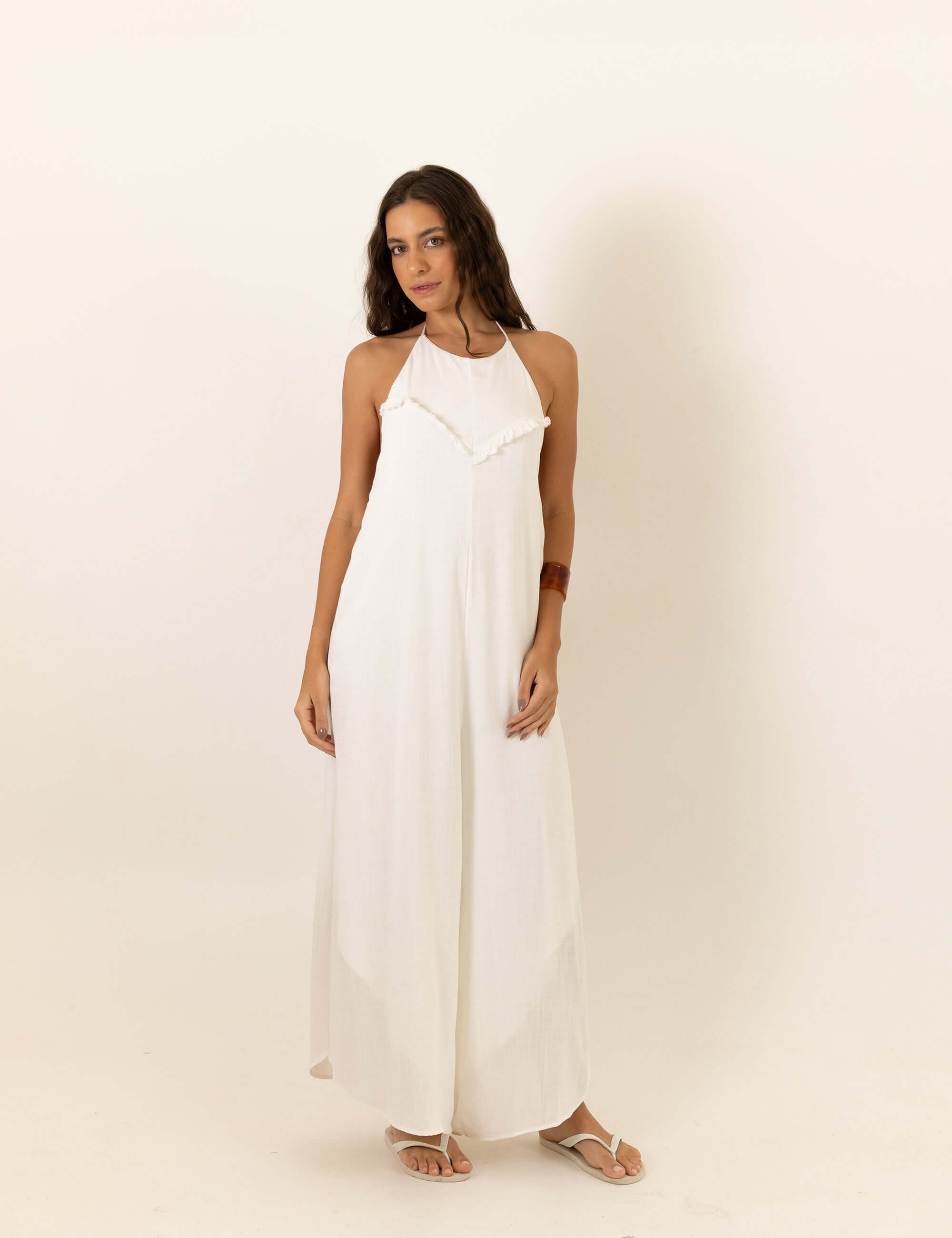 Mulher vestindo Macacão Frente Única Rustic - Off White da Greenish em fundo neutro, destacando fluidez e conforto para dias de sol.