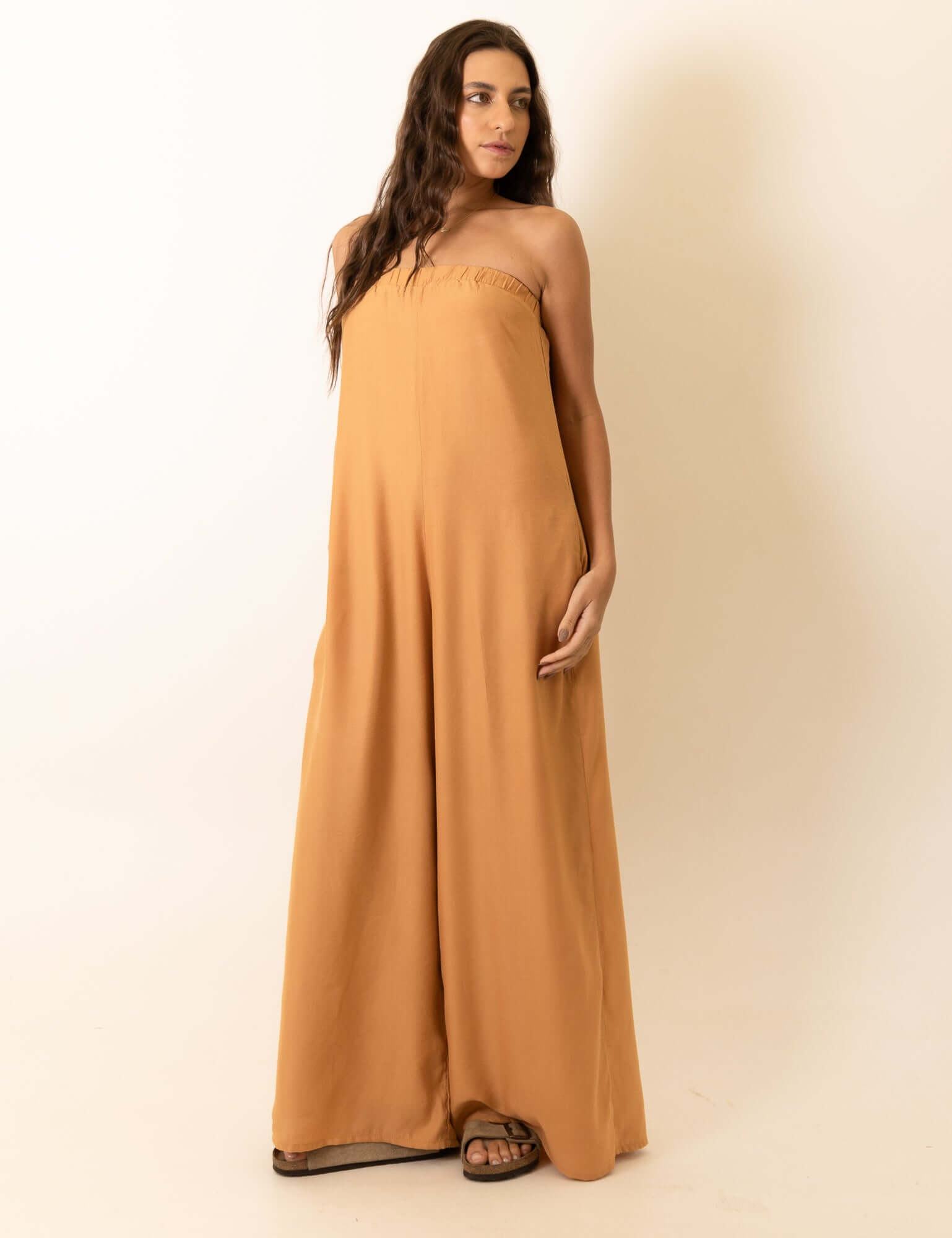 Mulher vestindo Macacão Leslie - Caqui da marca Greenish em estúdio, fundo branco.