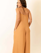 Modelo usando Macacão Leslie - Caqui por Greenish, visto por trás, destacando estilo e conforto.